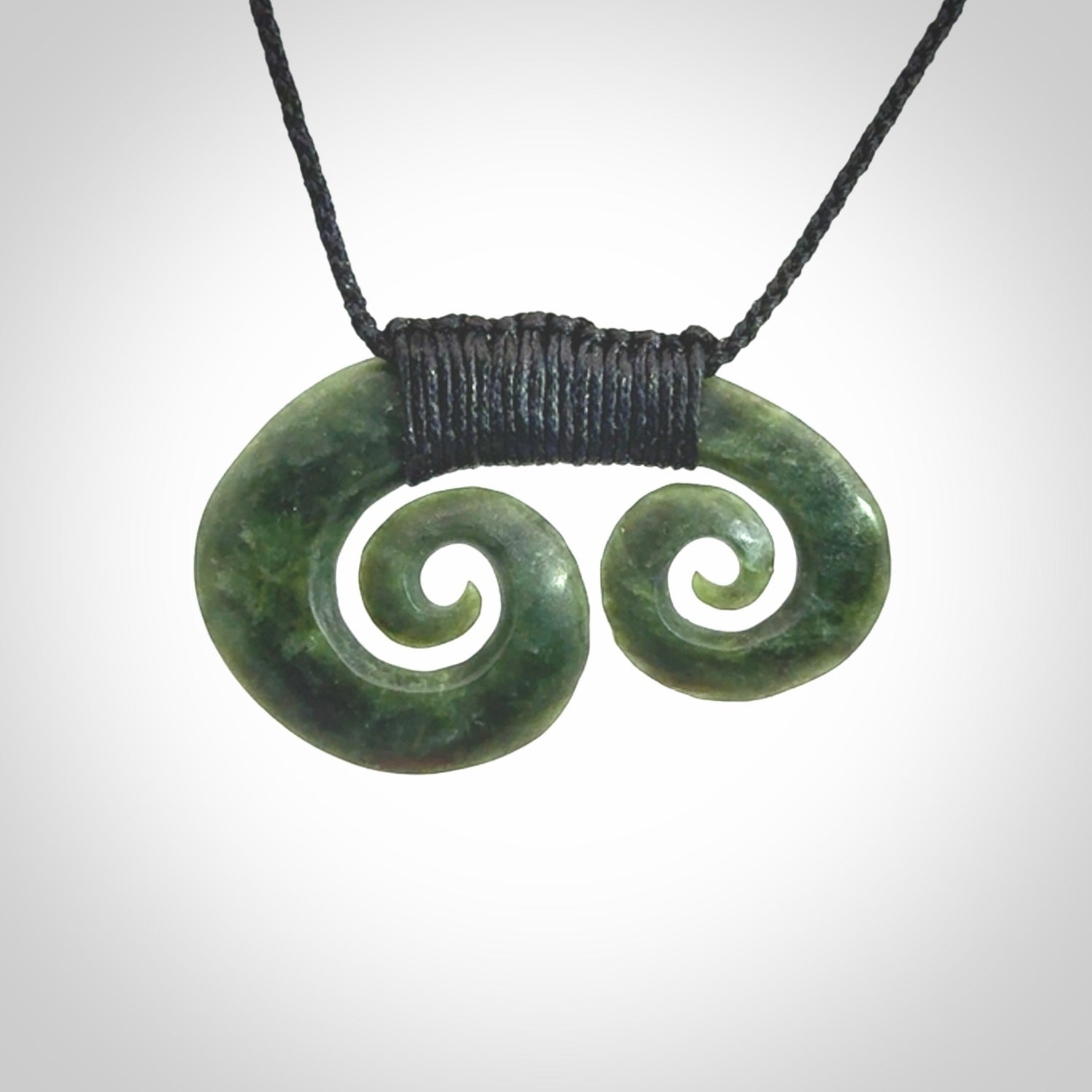Hand carved contemporary jade double koru jewellery. Made by Donna Summers for NZ Pacific from New Zealand greenstone.