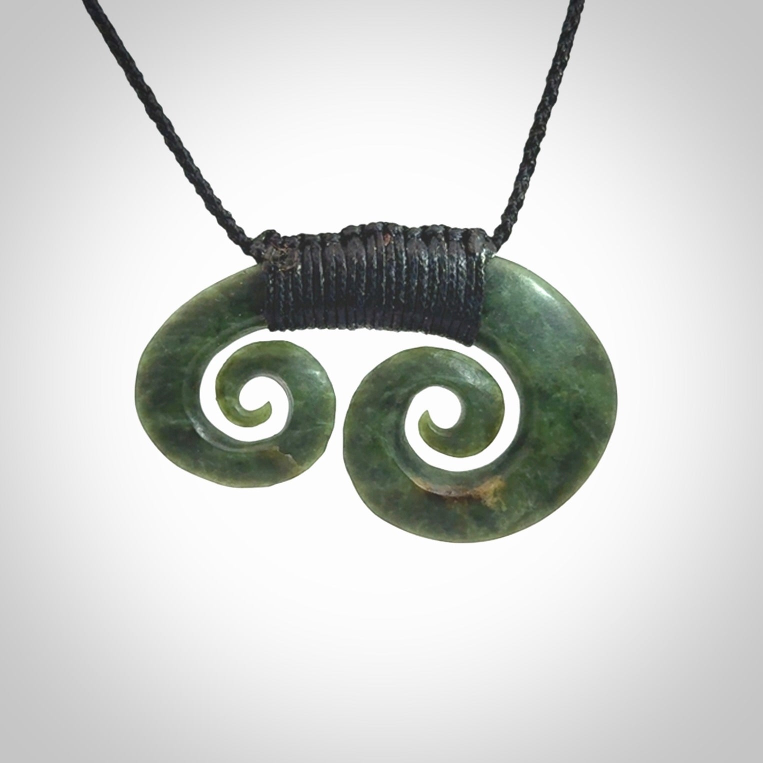 Hand carved contemporary jade double koru jewellery. Made by Donna Summers for NZ Pacific from New Zealand greenstone.