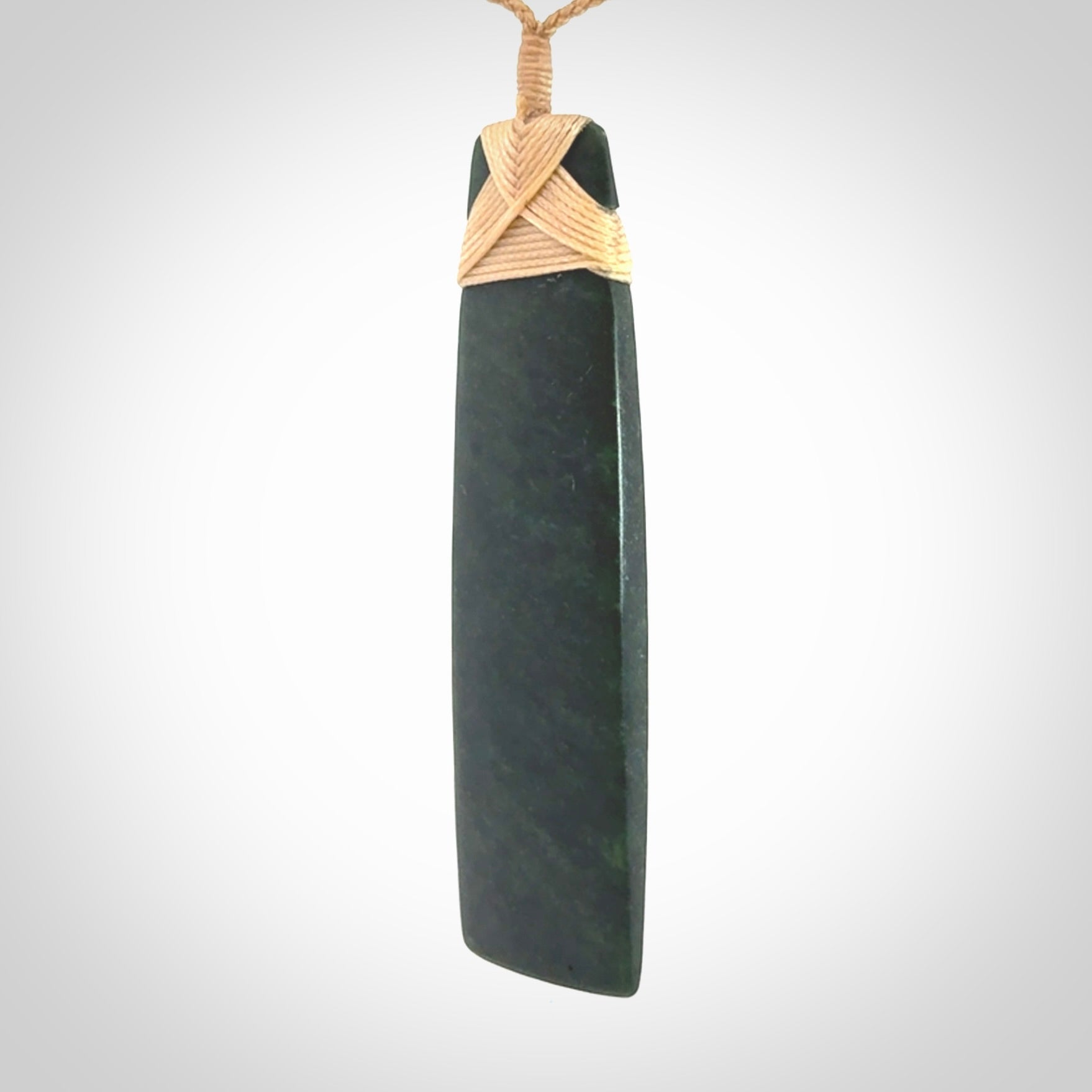 Hand carved from a lovely piece of local New Zealand Jade. We have suspended this from a 3-plait beige cord which can be adjusted with a couple of slip knots.