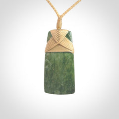 Hand carved from a lovely piece of local New Zealand Jade. We have suspended this from a 3-plait beige cord which can be adjusted with a couple of slip knots and beige binding.