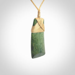 Hand carved from a lovely piece of local New Zealand Jade. We have suspended this from a 3-plait beige cord which can be adjusted with a couple of slip knots and beige binding.