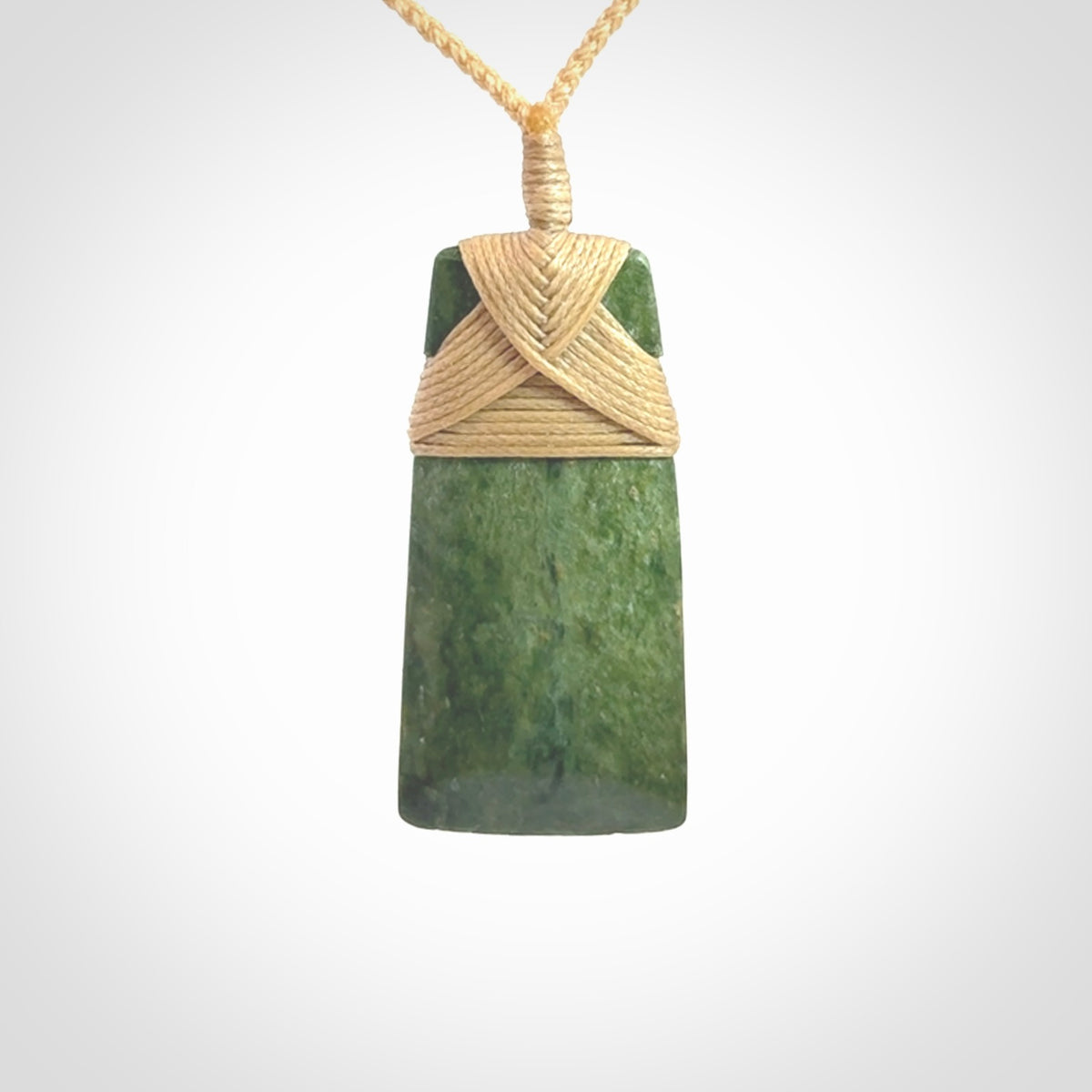 Hand carved from a lovely piece of local New Zealand Jade. We have suspended this from a 3-plait beige cord which can be adjusted with a couple of slip knots and beige binding.