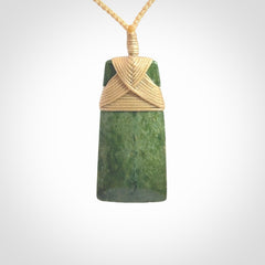 Hand carved from a lovely piece of local New Zealand Jade. We have suspended this from a 3-plait beige cord which can be adjusted with a couple of slip knots and beige binding.