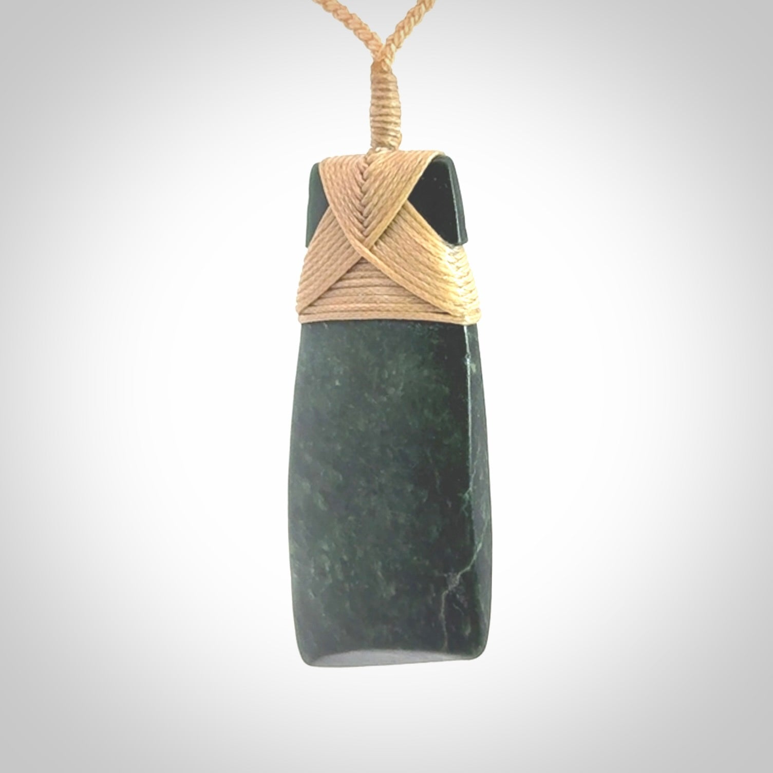 Hand carved from a lovely piece of local New Zealand Jade. We have suspended this from a 3-plait beige cord which can be adjusted with a couple of slip knots.