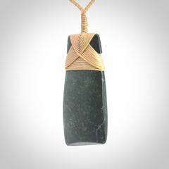 Hand carved from a lovely piece of local New Zealand Jade. We have suspended this from a 3-plait beige cord which can be adjusted with a couple of slip knots.