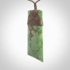 Hand carved from a lovely piece of local New Zealand Jade. We have suspended this from a 3-plait khaki cord which can be adjusted with a couple of slip knots and olive green binding.