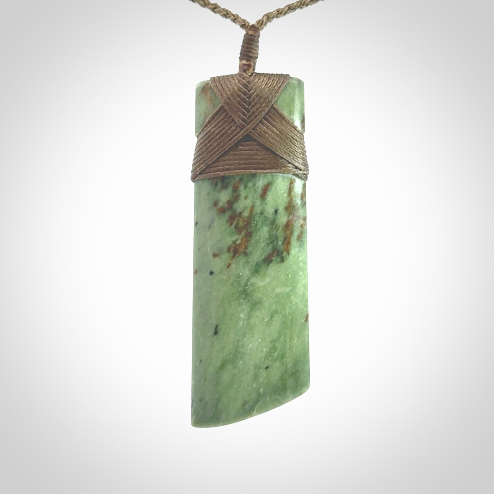 Hand carved from a lovely piece of local New Zealand Jade. We have suspended this from a 3-plait khaki cord which can be adjusted with a couple of slip knots and olive green binding.