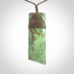 Hand carved from a lovely piece of local New Zealand Jade. We have suspended this from a 3-plait khaki cord which can be adjusted with a couple of slip knots and olive green binding.