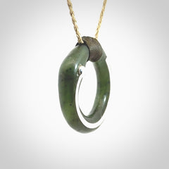 This picture shows a hand carved Nephrite jade circle pendant with sterling silver inlay. It is suspended from an adjustable Kalahari coloured cord. Delivery is free worldwide.
