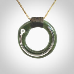 This picture shows a hand carved Nephrite jade circle pendant with sterling silver inlay. It is suspended from an adjustable Kalahari coloured cord. Delivery is free worldwide.
