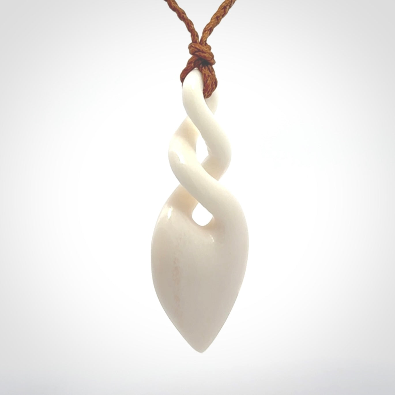 Hand carved bone double twist pendant. Beautiful hand made double twist bone necklace. Provided with an adjustable cord and packaged in a woven kete pouch. Free shipping worldwide.