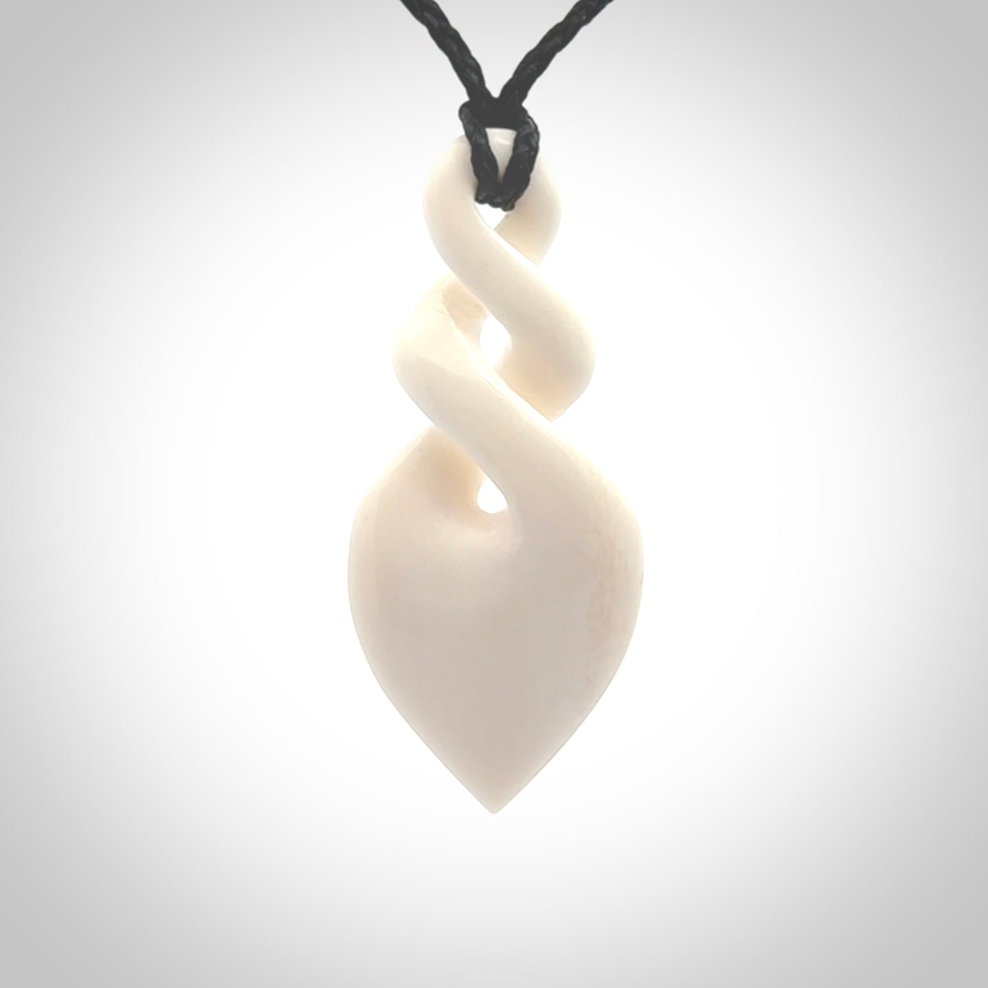 Hand carved bone double twist pendant. Beautiful hand made double twist bone necklace. Provided with an adjustable cord and packaged in a woven kete pouch. Free shipping worldwide.