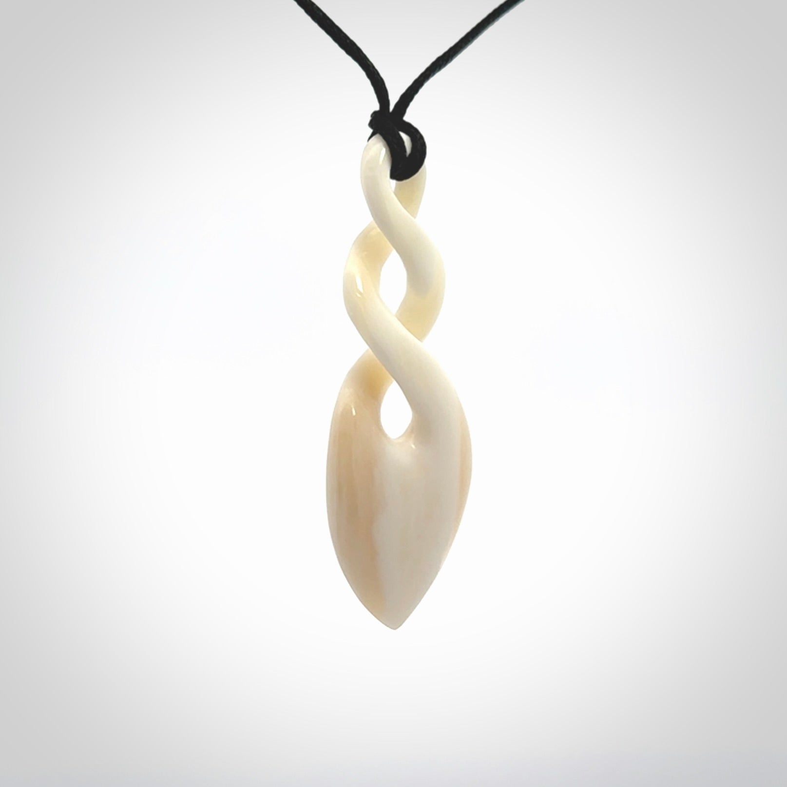 Hand carved bone double twist pendant. Beautiful hand made double twist bone necklace. Provided with an adjustable cord and packaged in a woven kete pouch. Free shipping worldwide.