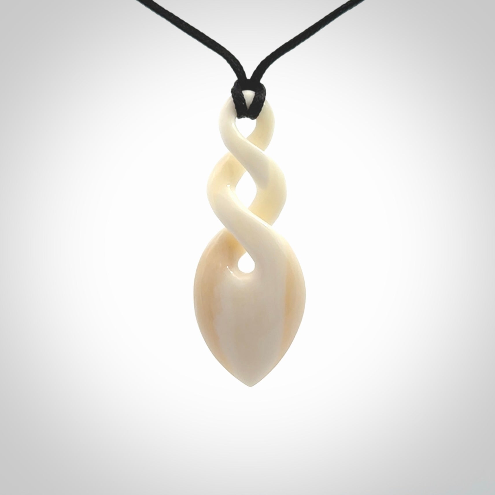 Hand carved bone double twist pendant. Beautiful hand made double twist bone necklace. Provided with an adjustable cord and packaged in a woven kete pouch. Free shipping worldwide.