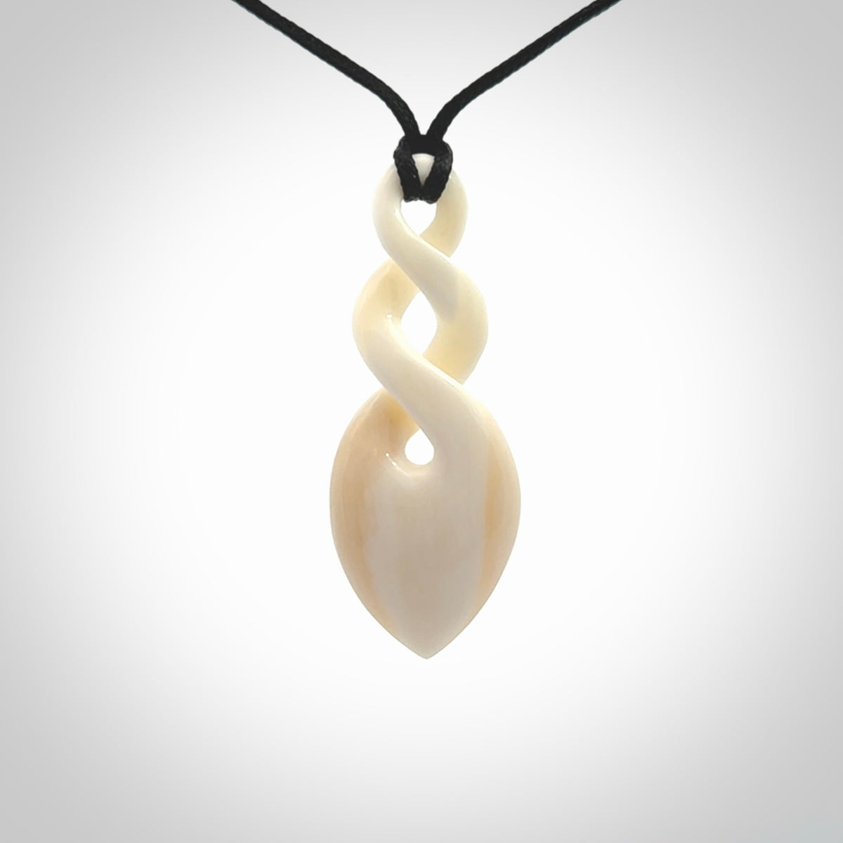Hand carved bone double twist pendant. Beautiful hand made double twist bone necklace. Provided with an adjustable cord and packaged in a woven kete pouch. Free shipping worldwide.