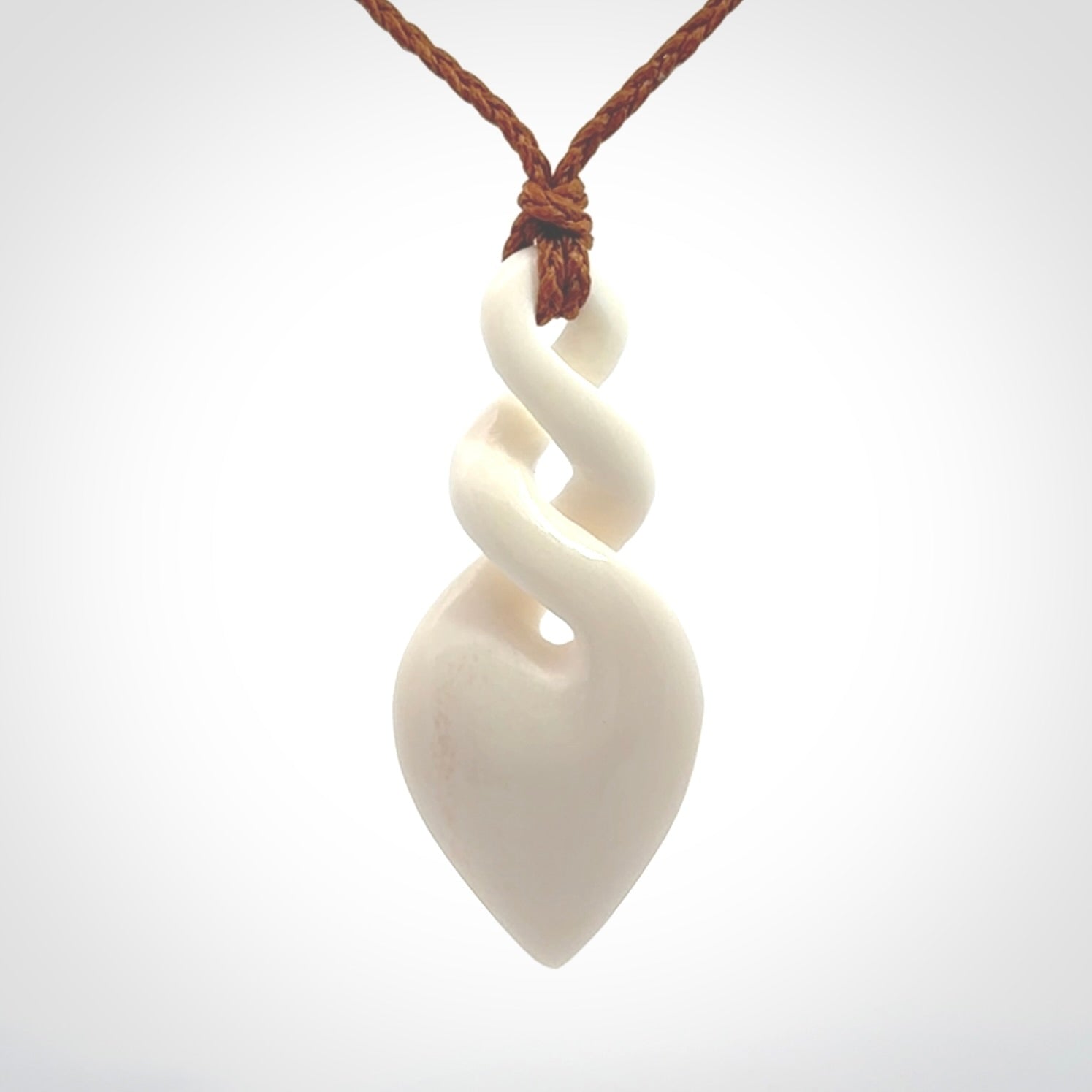 Hand carved bone double twist pendant. Beautiful hand made double twist bone necklace. Provided with an adjustable cord and packaged in a woven kete pouch. Free shipping worldwide.