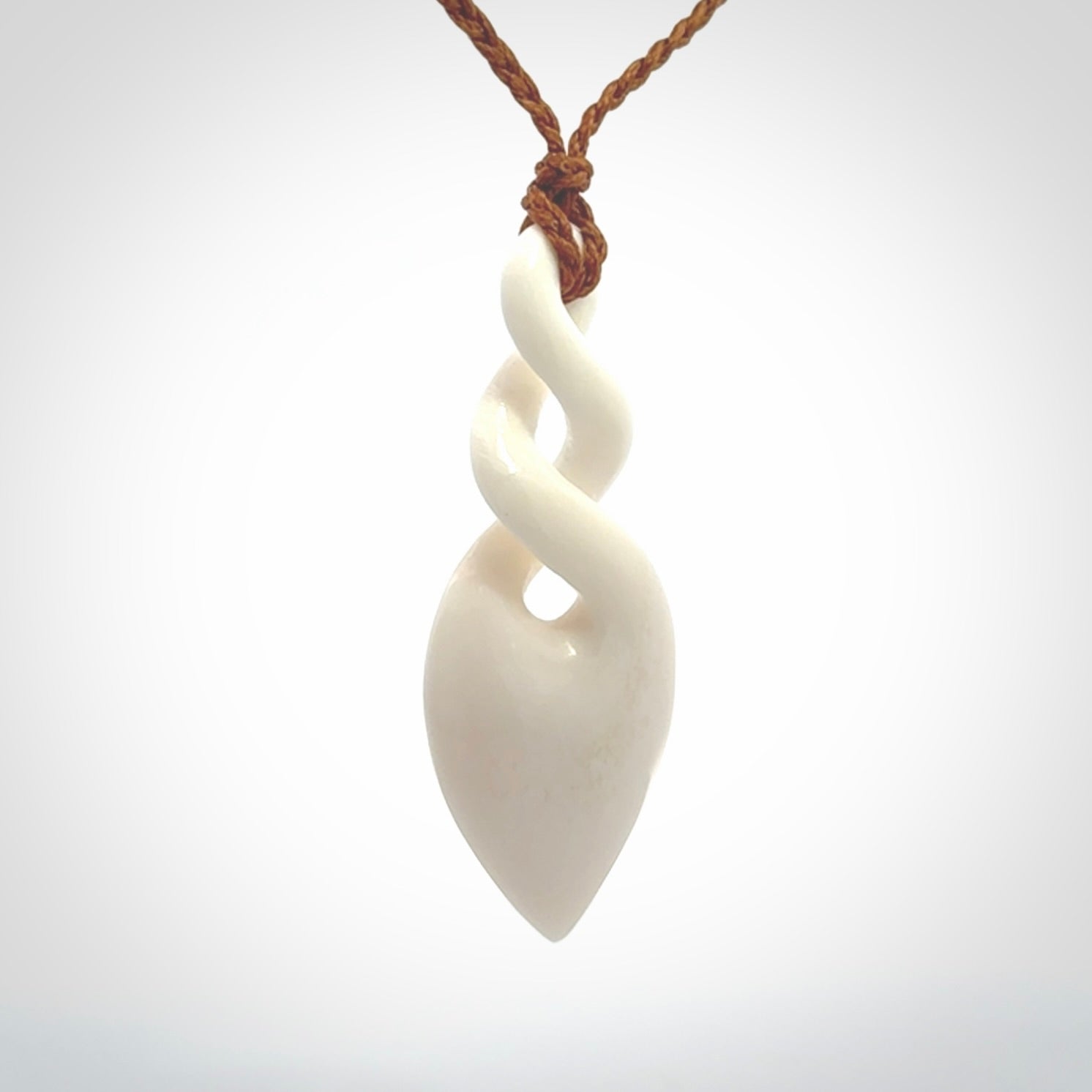 Hand carved bone double twist pendant. Beautiful hand made double twist bone necklace. Provided with an adjustable cord and packaged in a woven kete pouch. Free shipping worldwide.