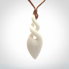 Hand carved bone double twist pendant. Beautiful hand made double twist bone necklace. Provided with an adjustable cord and packaged in a woven kete pouch. Free shipping worldwide.