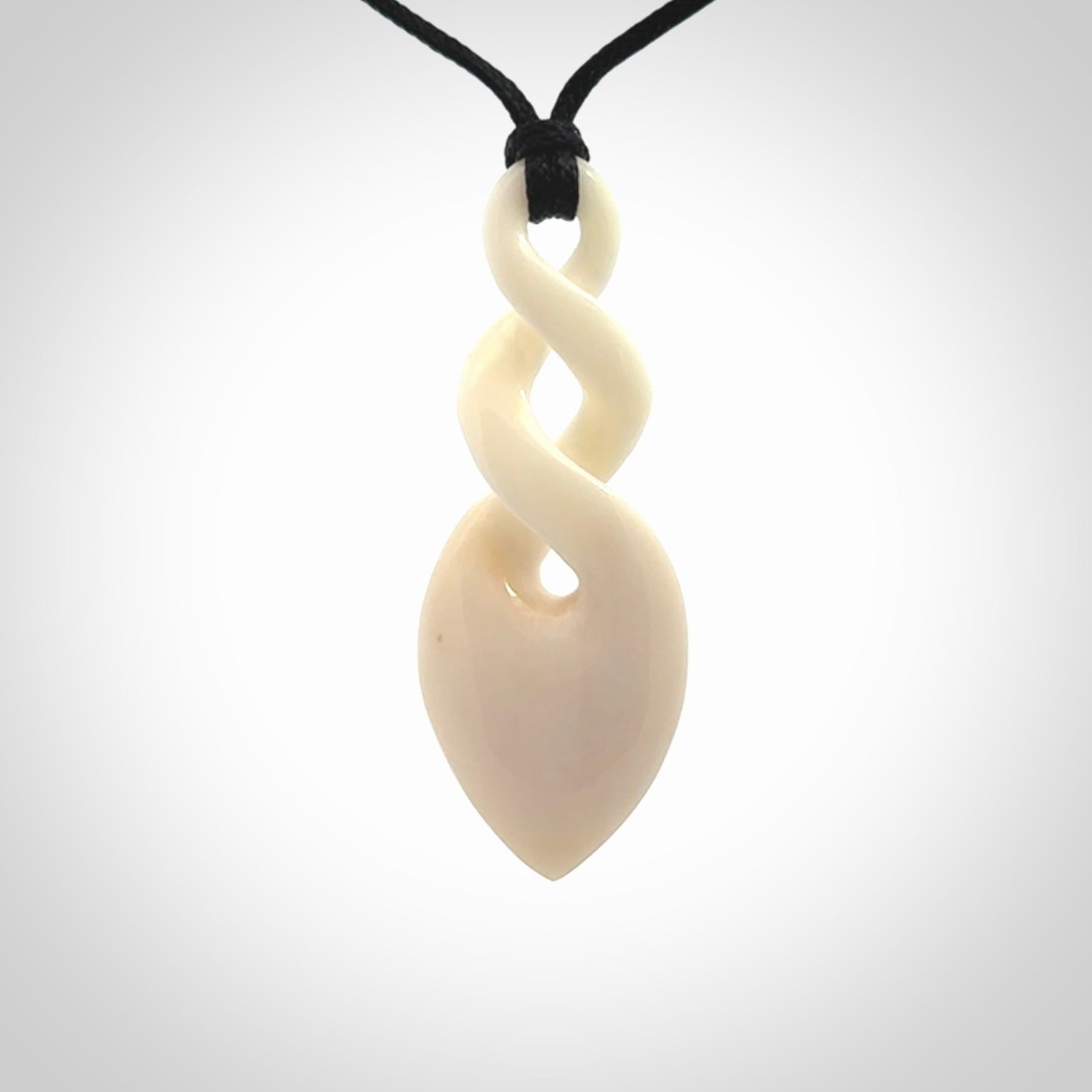 Hand carved bone double twist pendant. Beautiful hand made double twist bone necklace. Provided with an adjustable cord and packaged in a woven kete pouch. Free shipping worldwide.