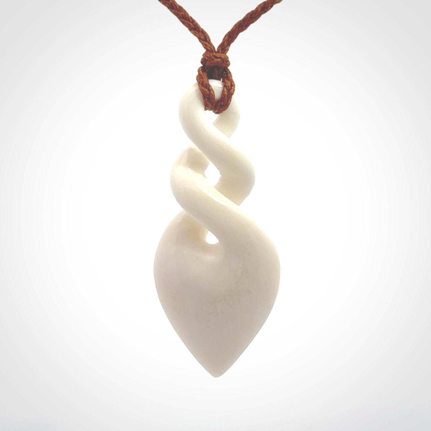 Hand carved bone double twist pendant. Beautiful hand made double twist bone necklace. Provided with an adjustable cord and packaged in a woven kete pouch. Free shipping worldwide.