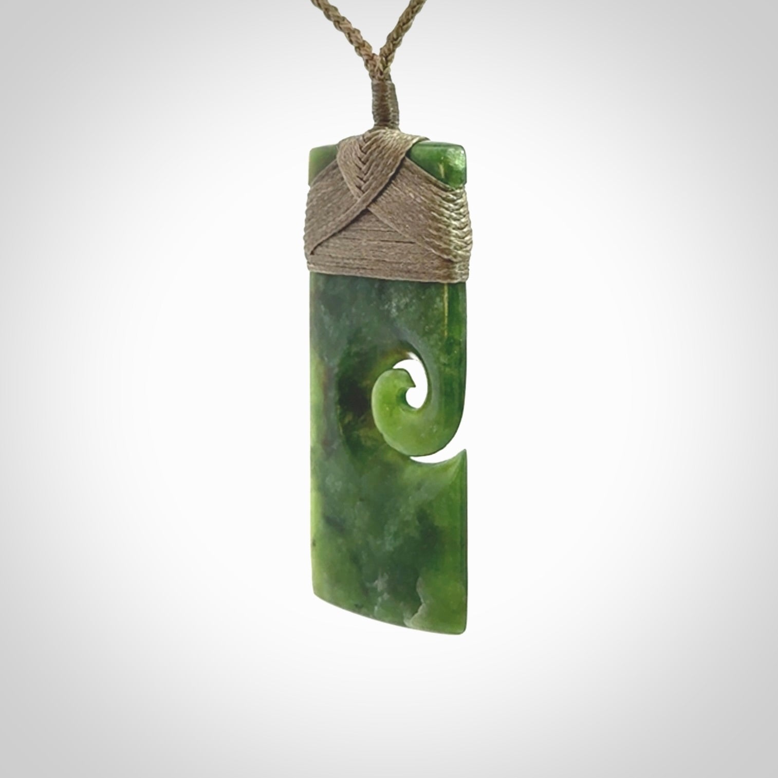 New Zealand jade toki koru pendant. Hand carved in New Zealand. Hand made jewellery. Provided with an adjustable cord.