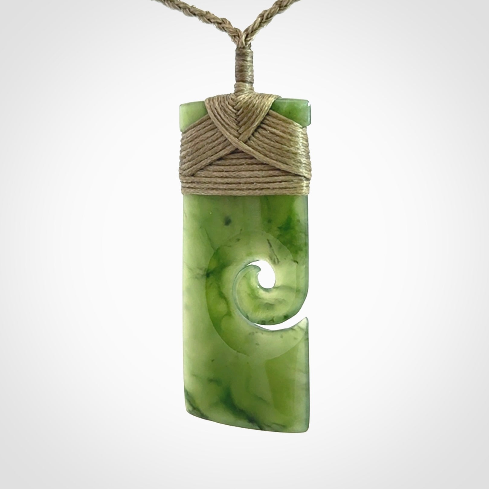 New Zealand jade toki koru pendant. Hand carved in New Zealand. Hand made jewellery. Provided with an adjustable cord.