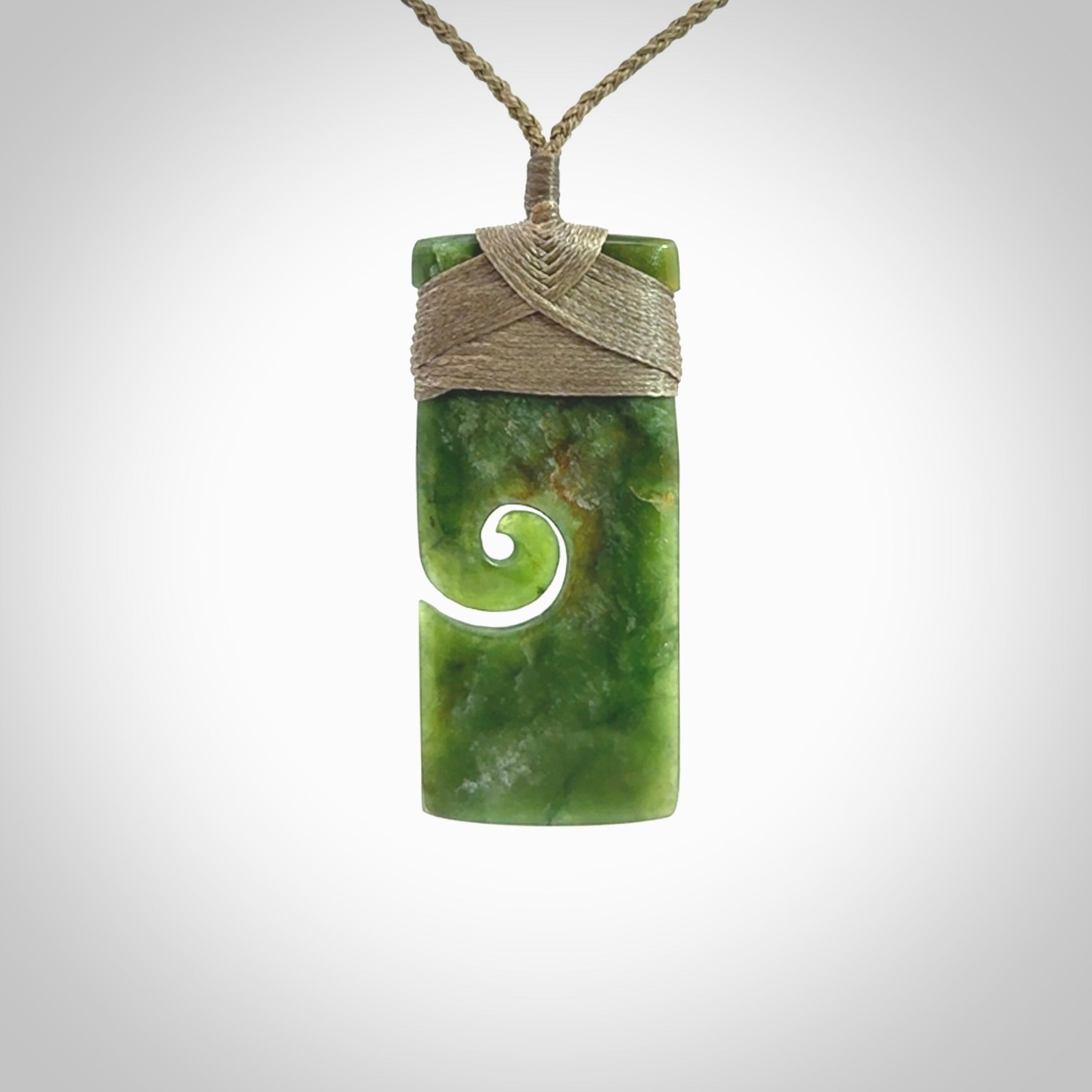 New Zealand jade toki koru pendant. Hand carved in New Zealand. Hand made jewellery. Provided with an adjustable cord.