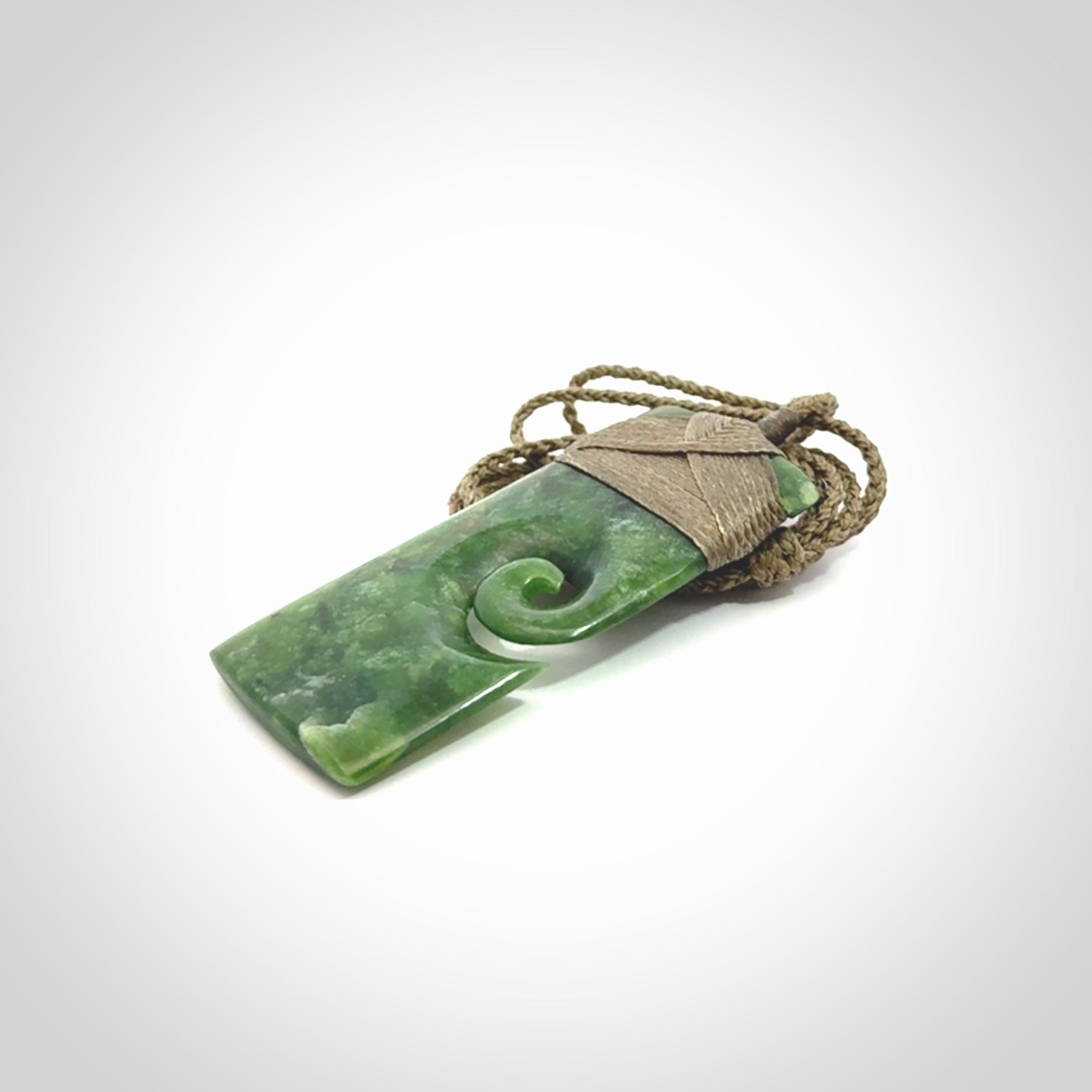 New Zealand jade toki koru pendant. Hand carved in New Zealand. Hand made jewellery. Provided with an adjustable cord.