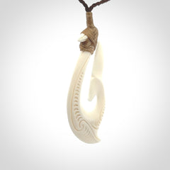 A handcarved hook pendant with a whaletail end. This is carved from bone and is detailed with a traditional Maori engraved design. We will ship this piece to you anywhere in the world and the price for shipping is included in the price. Unique bone jewellery for sale online at www.nzpacific.com