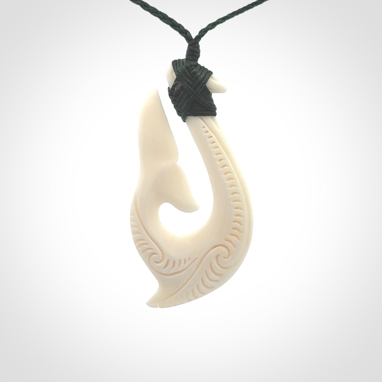 A handcarved hook pendant with a whaletail end. This is carved from bone and is detailed with a traditional Maori engraved design. We will ship this piece to you anywhere in the world and the price for shipping is included in the price. Unique bone jewellery for sale online at www.nzpacific.com