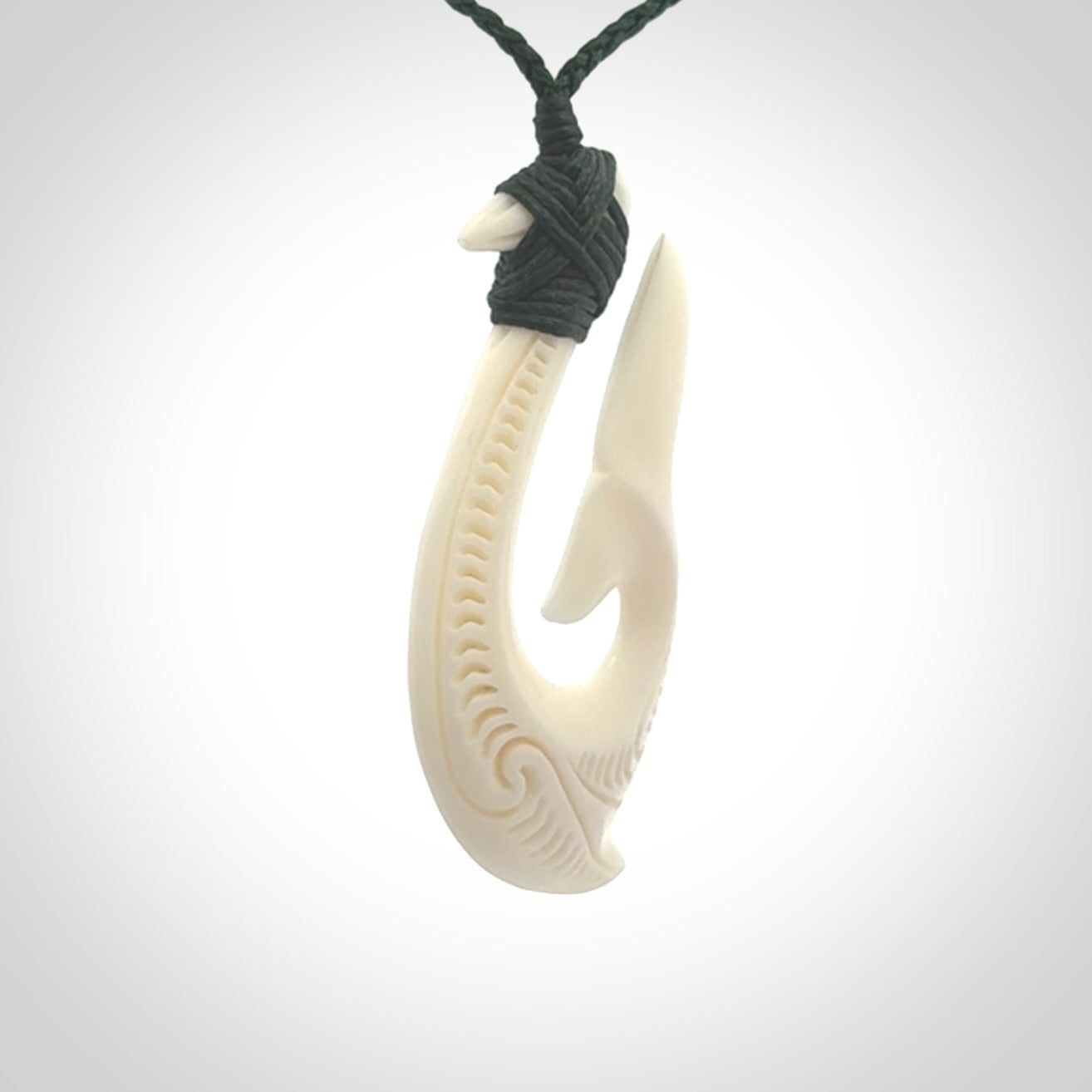 A handcarved hook pendant with a whaletail end. This is carved from bone and is detailed with a traditional Maori engraved design. We will ship this piece to you anywhere in the world and the price for shipping is included in the price. Unique bone jewellery for sale online at www.nzpacific.com