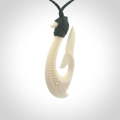 A handcarved hook pendant with a whaletail end. This is carved from bone and is detailed with a traditional Maori engraved design. We will ship this piece to you anywhere in the world and the price for shipping is included in the price. Unique bone jewellery for sale online at www.nzpacific.com