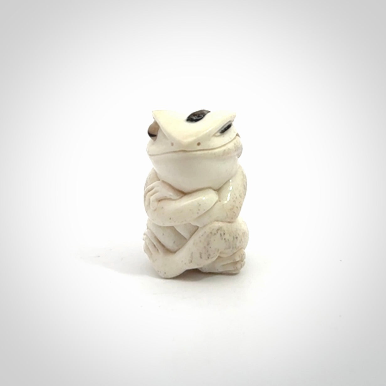 Hand carved meditating frog with slug on its head, made from Deer antler and black mother of pearl. Hand made by master bone carver Fumio Noguchi. Spectacular collectable work of art to display. One only, delivered to you at no extra cost with express courier.