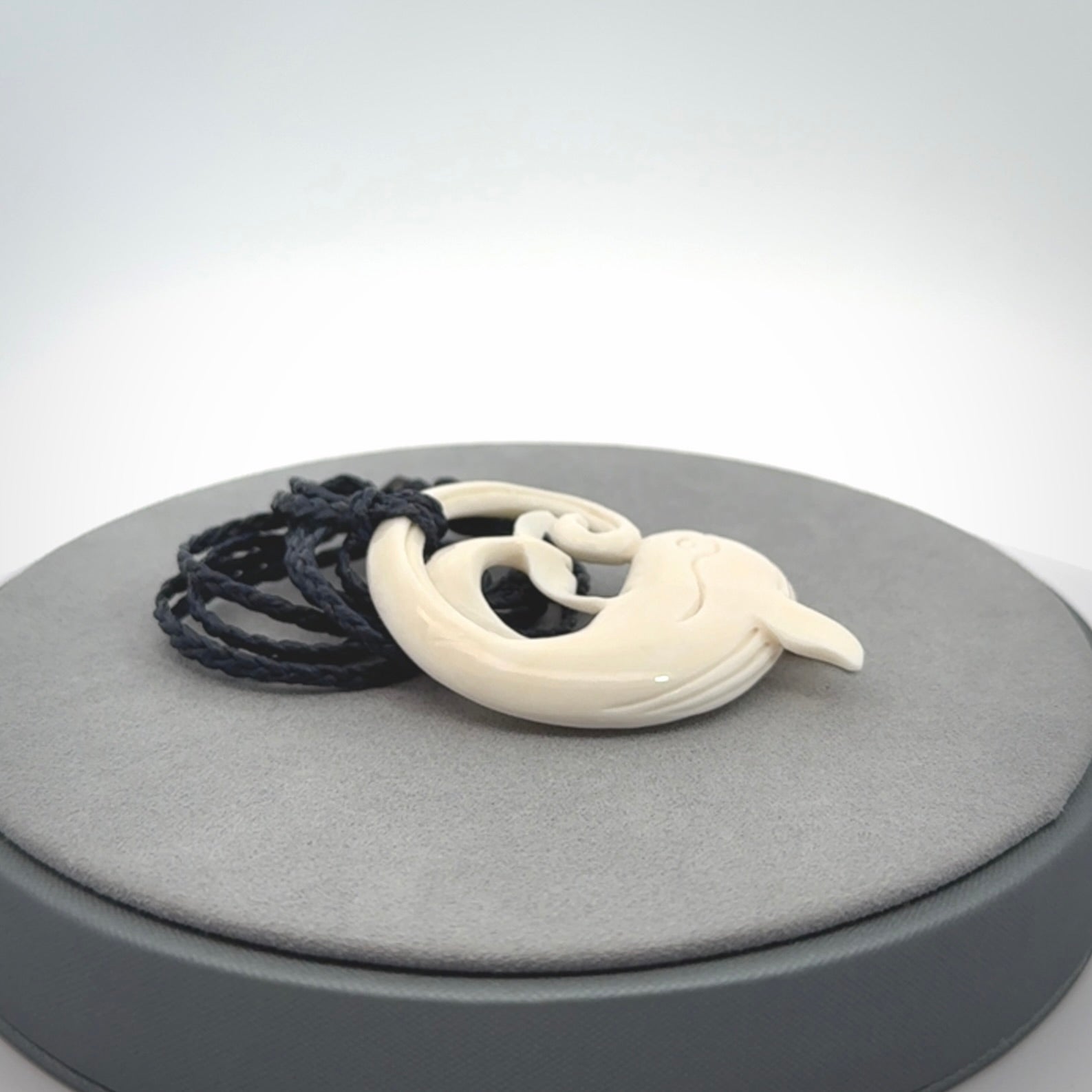 A hand carved bone whale pendant. This is a lovely piece carved to bring pleasure to the lucky wearer. It is a friendly pendant which we will ship to you free wherever you live. Carved by NZ Pacific and for sale online. Provided with an adjustable dark blue cord.