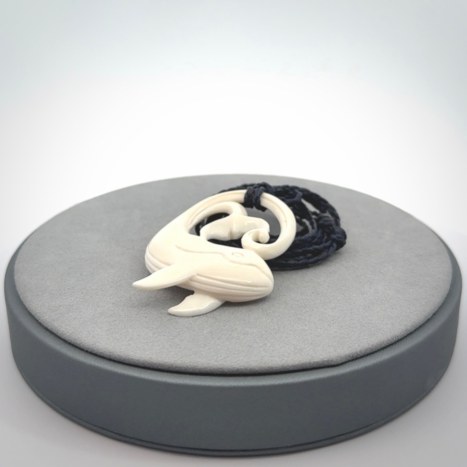 A hand carved bone whale pendant. This is a lovely piece carved to bring pleasure to the lucky wearer. It is a friendly pendant which we will ship to you free wherever you live. Carved by NZ Pacific and for sale online. Provided with an adjustable dark blue cord.