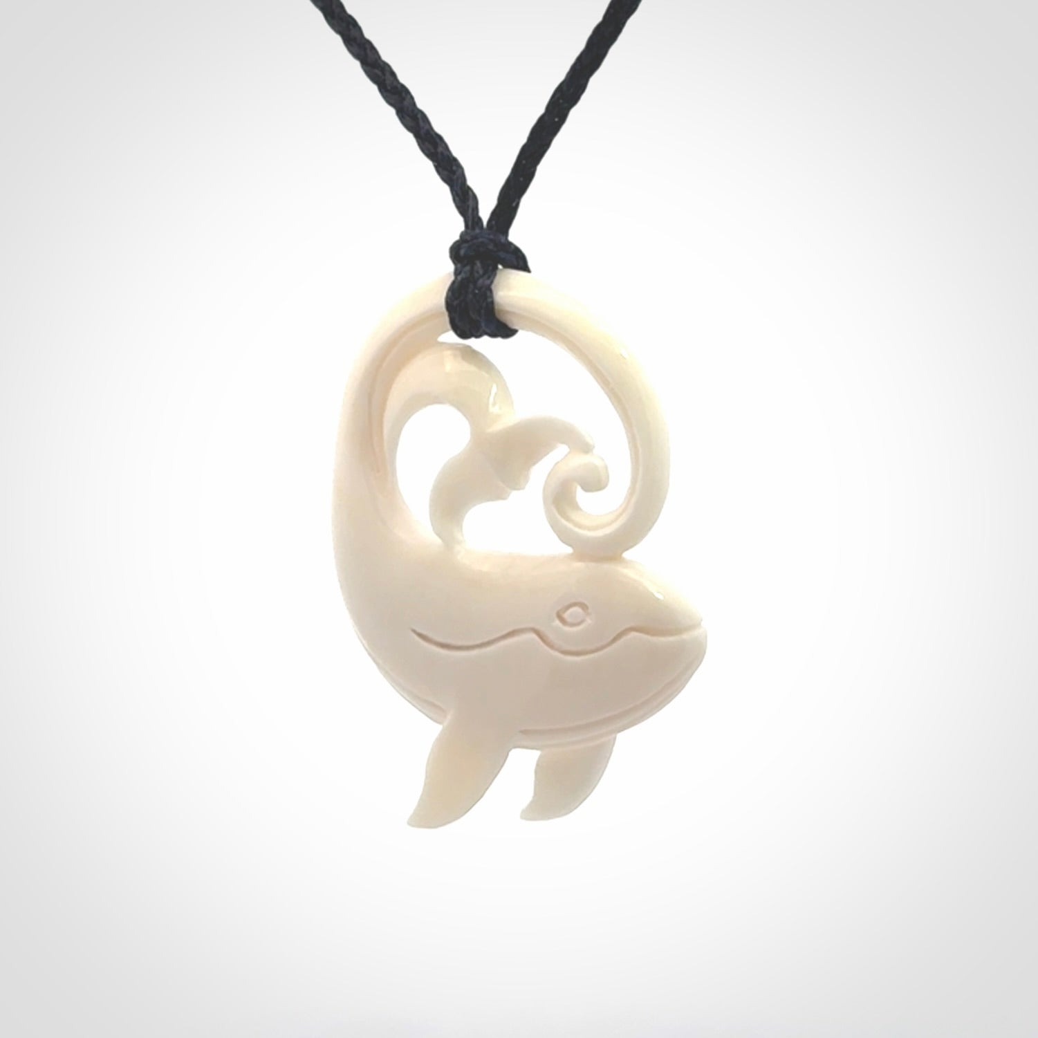 A hand carved bone whale pendant. This is a lovely piece carved to bring pleasure to the lucky wearer. It is a friendly pendant which we will ship to you free wherever you live. Carved by NZ Pacific and for sale online. Provided with an adjustable dark blue cord.
