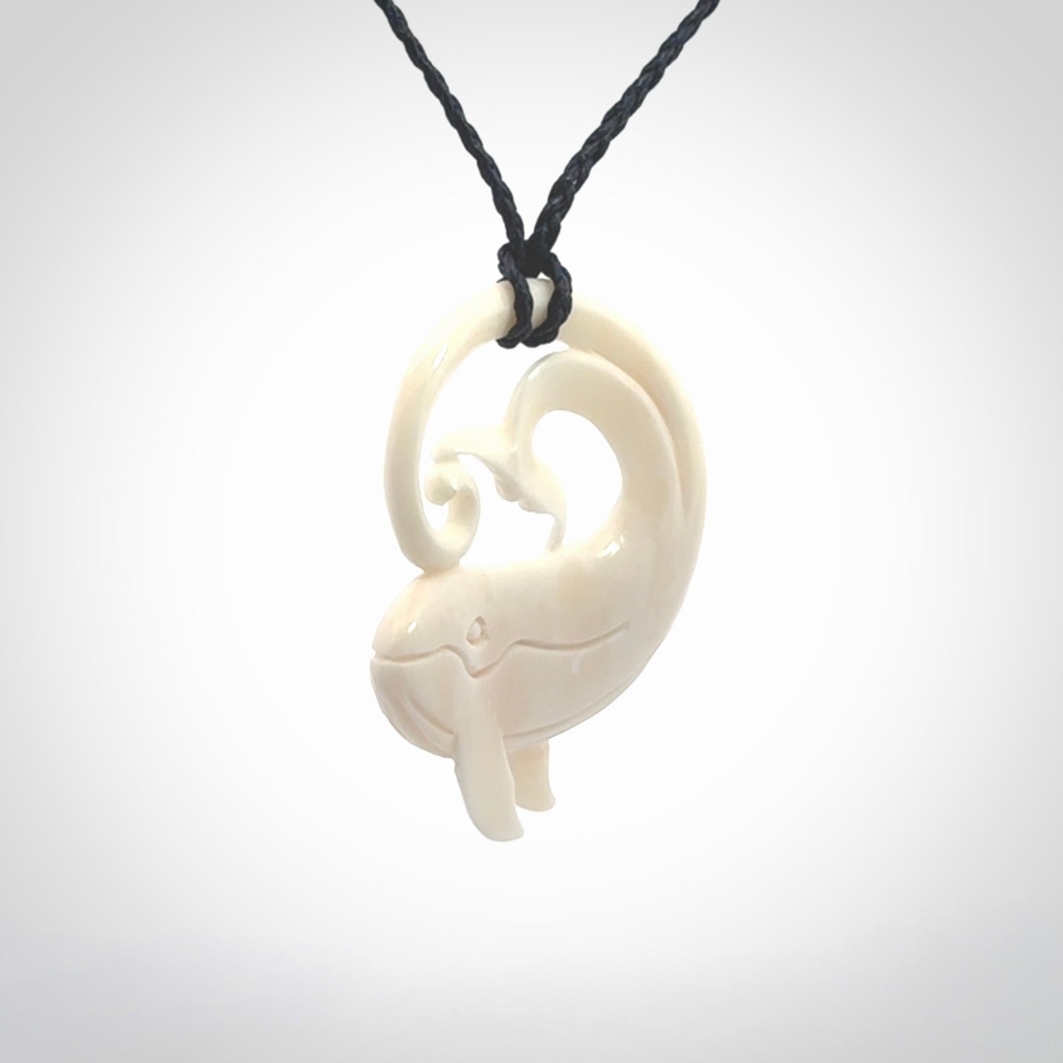 A hand carved bone whale pendant. This is a lovely piece carved to bring pleasure to the lucky wearer. It is a friendly pendant which we will ship to you free wherever you live. Carved by NZ Pacific and for sale online. Provided with an adjustable dark blue cord.