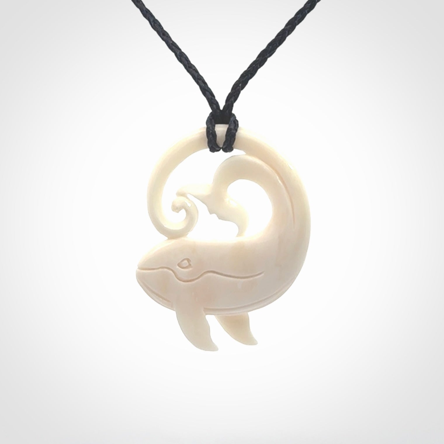 A hand carved bone whale pendant. This is a lovely piece carved to bring pleasure to the lucky wearer. It is a friendly pendant which we will ship to you free wherever you live. Carved by NZ Pacific and for sale online. Provided with an adjustable dark blue cord.