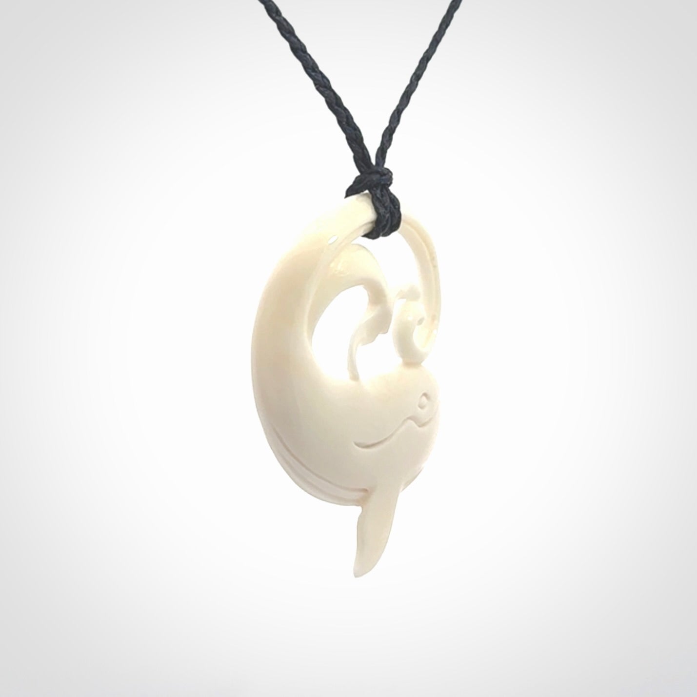 A hand carved bone whale pendant. This is a lovely piece carved to bring pleasure to the lucky wearer. It is a friendly pendant which we will ship to you free wherever you live. Carved by NZ Pacific and for sale online. Provided with an adjustable dark blue cord.