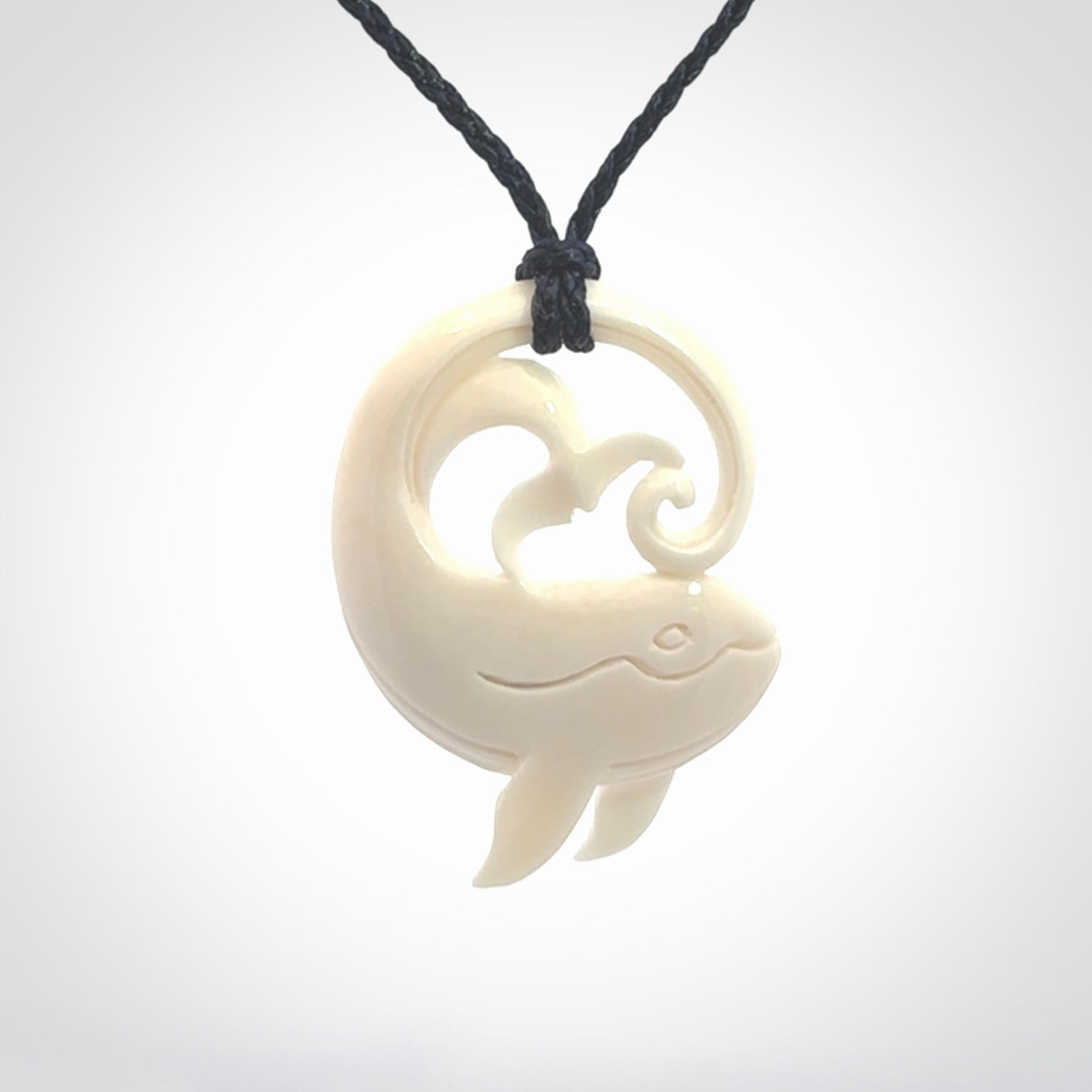 A hand carved bone whale pendant. This is a lovely piece carved to bring pleasure to the lucky wearer. It is a friendly pendant which we will ship to you free wherever you live. Carved by NZ Pacific and for sale online. Provided with an adjustable dark blue cord.