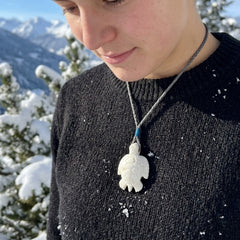 Person wearing turtle pendant