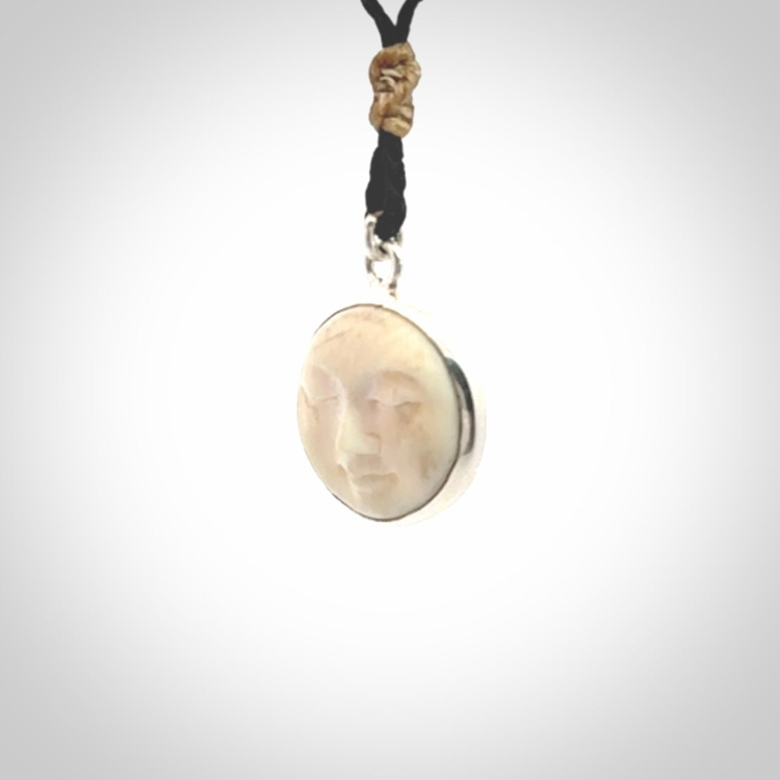 Hand made woolly mammoth tusk moon face necklace. Made by NZ Pacific and sale online only. Delivered with adjustable cord and packaged in a woven kete pouch.
