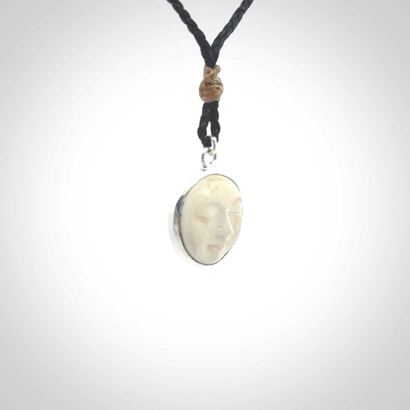 Hand made woolly mammoth tusk moon face necklace. Made by NZ Pacific and sale online only. Delivered with adjustable cord and packaged in a woven kete pouch.
