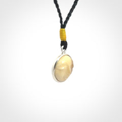 Hand made woolly mammoth tusk moon face necklace. Made by NZ Pacific and sale online only. Delivered with adjustable cord and packaged in a woven kete pouch.