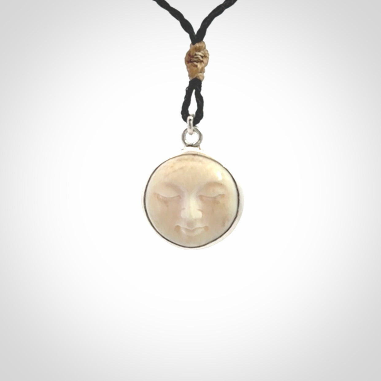Hand made woolly mammoth tusk moon face necklace. Made by NZ Pacific and sale online only. Delivered with adjustable cord and packaged in a woven kete pouch.