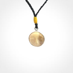 Hand made woolly mammoth tusk moon face necklace. Made by NZ Pacific and sale online only. Delivered with adjustable cord and packaged in a woven kete pouch.