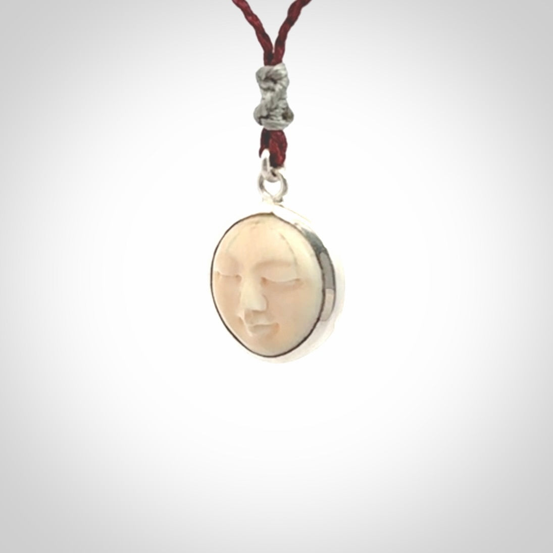Hand made woolly mammoth tusk moon face necklace. Made by NZ Pacific and sale online only. Delivered with adjustable cord and packaged in a woven kete pouch.