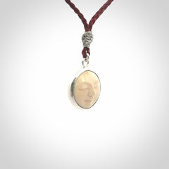 Hand made woolly mammoth tusk moon face necklace. Made by NZ Pacific and sale online only. Delivered with adjustable cord and packaged in a woven kete pouch.