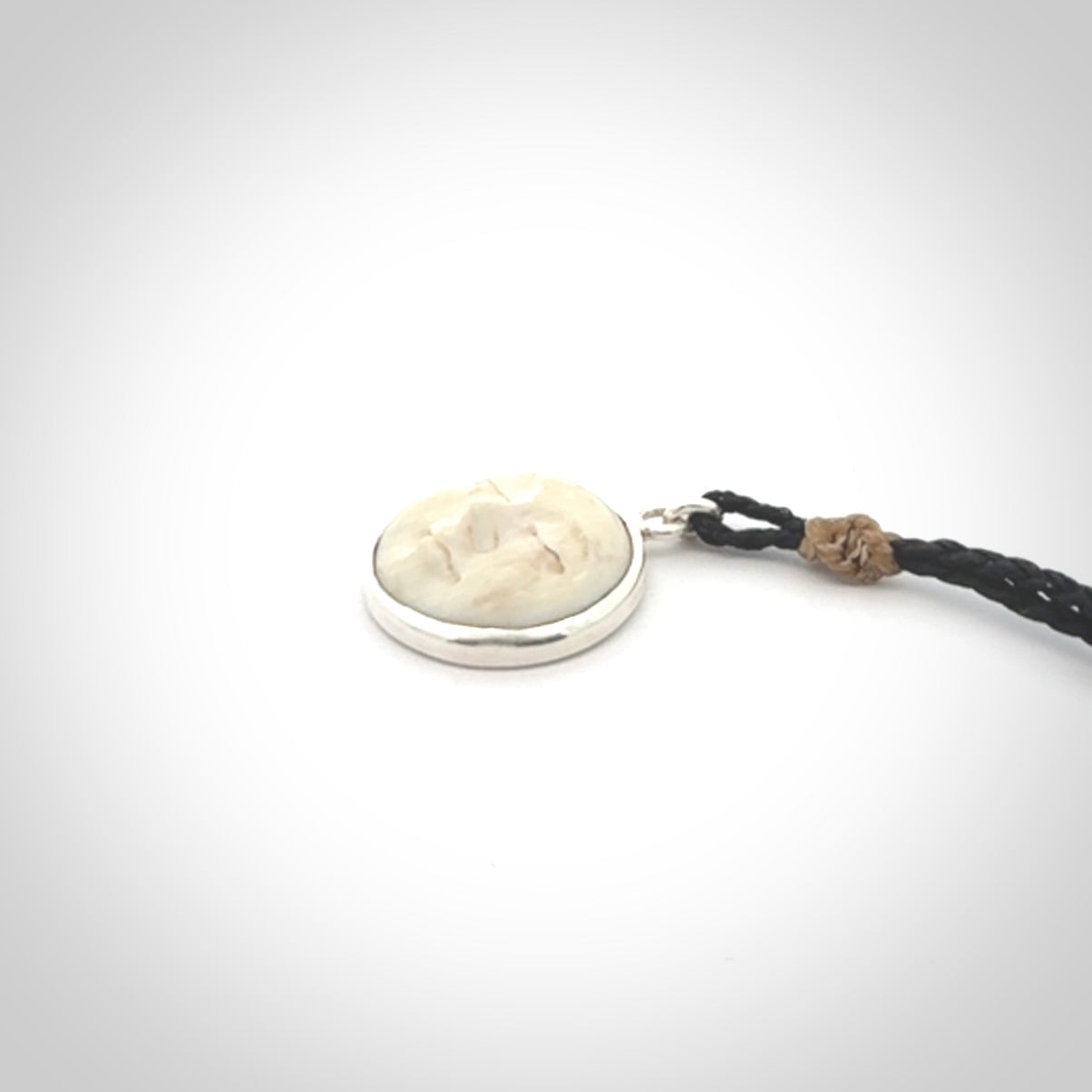 Hand made woolly mammoth tusk moon face necklace. Made by NZ Pacific and sale online only. Delivered with adjustable cord and packaged in a woven kete pouch.