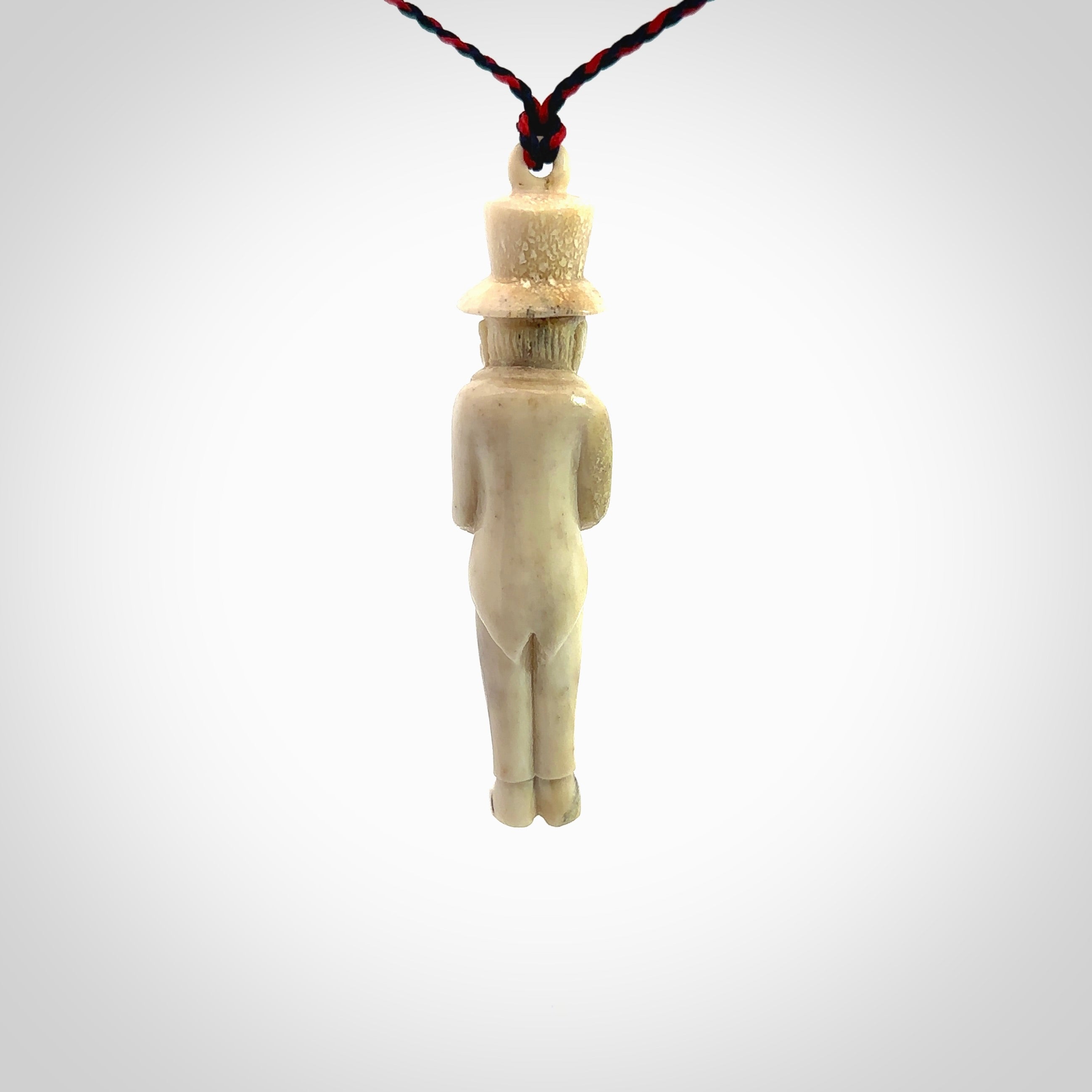 This unique contemporary hunchback with red pepper piece is hand carved in deer antler, bone and is a one off pendant. It is a delightful, large sized and artistic piece of jewellery. One only necklace. We provide this pendant on a blue and red adjustable cord.